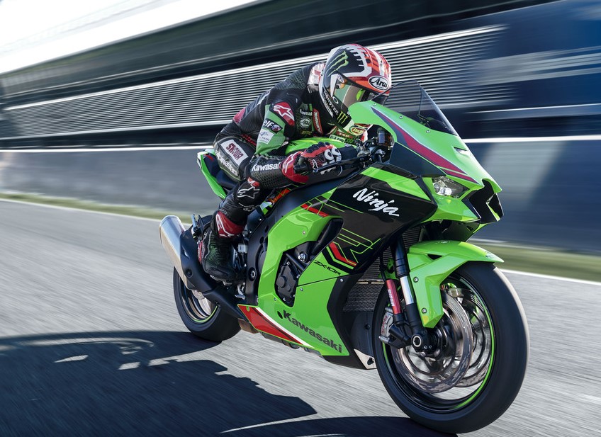 a motorcycle racer riding a green and black Kawasaki at high speed